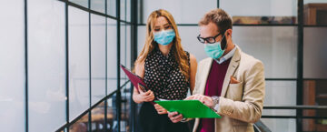 Businesspeople wearing masks in the office for illness prevention during COVID-19 pandemic