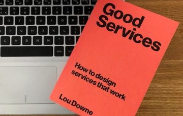 (alt="the cover of the book, good services by Lou Downe on a laptop")
