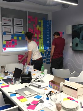 Live analysis with various coloured post it notes stuck to the wall, during usability testing for Just Eat