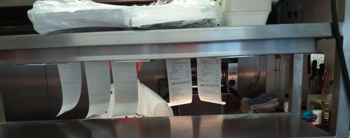 Order receipts pinned up in restaurant kitchen