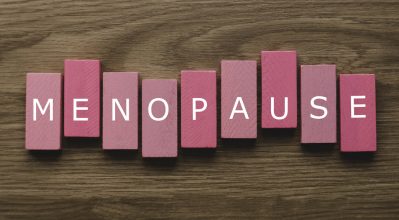 The word menopause written on pink wooden blocks.